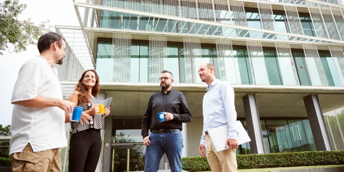 four people standing infront of a building