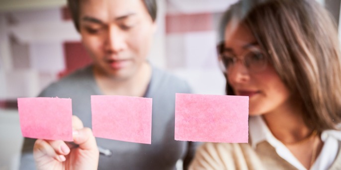 Employees sticking post it on a wall