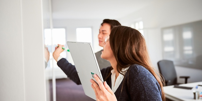 Mitarbeitende arbeiten am Whiteboard