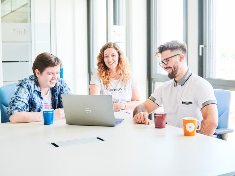 Mitarbeitende im Gespräch am Notebook