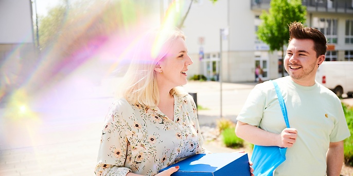 Mitarbeitende tragen ein blaues Paket