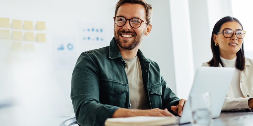 Workshop participants working on laptops. In the background are Post-Its and other materials for practical exercises.